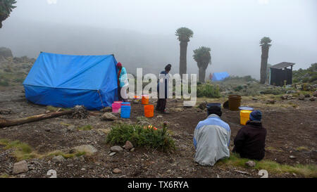 Mount Kilimanjaro/Tansania: 4. Januar 2016: Hochlager auf dem Mount Kilimanjaro mit vielen Menschen Vorbereitung und Einrichtung der Lager Stockfoto