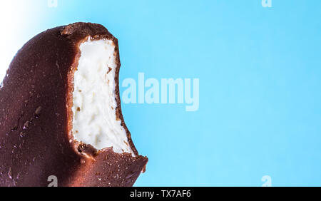 Eis am Stiel in Schokolade Glasur close-up mit Kondensat und Eisbildung Frost im Sommer blauer Himmel gebissen. Eis Textur. Stockfoto