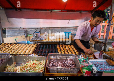 Kyoto, Japan - 21. November 2018: Mann kochen takoyaki auf Street Food Festival außerhalb Fushimi Inari Schrein. Stockfoto