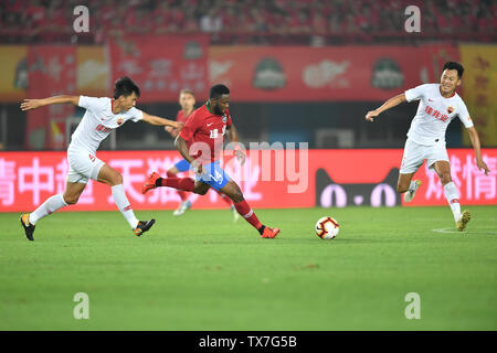 Kamerunischer Fußballspieler Franck Ohandza, Mitte, Henan Jianye passt den Ball gegen Spieler von Shenzhen F.C. in der 14. Runde während der 2019 chinesischen Fußballverband Super League (CSL) in Zhengzhou City, Central China Provinz Henan, 22. Juni 2019. Henan Jianye besiegt Shenzhen F.C. 1-0. Stockfoto