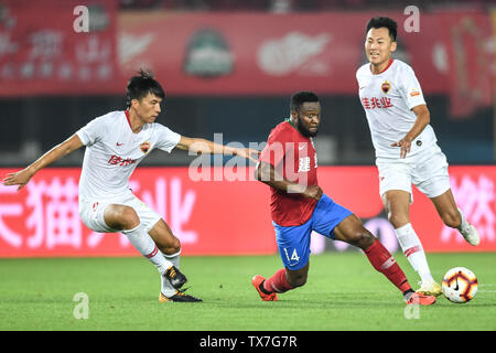 Kamerunischer Fußballspieler Franck Ohandza, Mitte, Henan Jianye passt den Ball gegen Spieler von Shenzhen F.C. in der 14. Runde während der 2019 chinesischen Fußballverband Super League (CSL) in Zhengzhou City, Central China Provinz Henan, 22. Juni 2019. Henan Jianye besiegt Shenzhen F.C. 1-0. Stockfoto