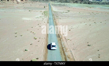 Einziges Auto auf einem alten Wüste Straße, Antenne folgen Bild. Stockfoto