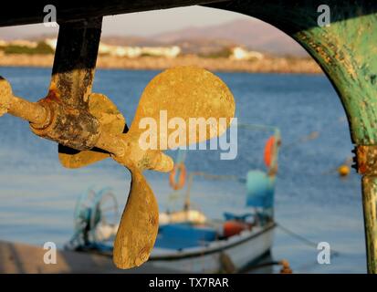 Segelboot Propeller im Vordergrund und ein Fischerboot im Hintergrund. Der Hafen von kokkinos Pyrgos, Kreta, Griechenland. Stockfoto