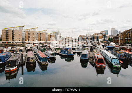 Narrowboats in Limehouse Basin im East End von London, auf der Suche nach Osten in Richtung Canary Wharf und Limeouse Kirche Stockfoto