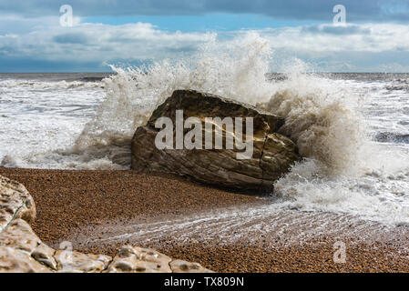 Wellen gegen die Felsen während eines Winters Sturm auf einem Dorset Strand Stockfoto