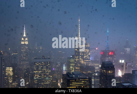 Manhattan Skyline der Stadt durch einen regen splattered Fenster bei Nacht, New York, USA Stockfoto