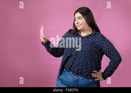 Schöne mollige Frau tanzen und singen mit rosa Hintergrund Stockfoto