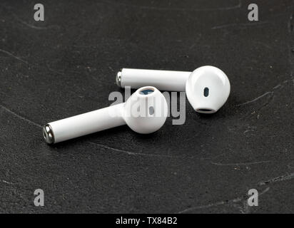 White kabellose Bluetooth® Kopfhörer auf dunklen konkreten Hintergrund Stockfoto