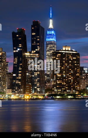 Manhatttan Skyline bei Nacht mit der amerikanischen Kupfer Gebäude und Empire State Building über den East River, New York, USA
