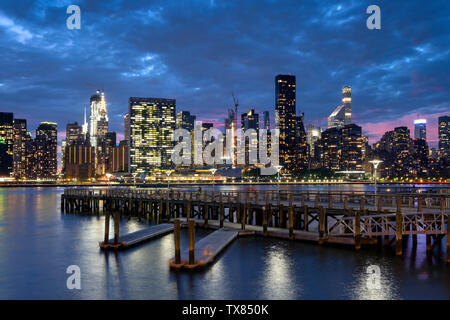 Skyline von Manhattan aus Gantry Plaza State Park Pier bei Nacht, New York, USA Stockfoto