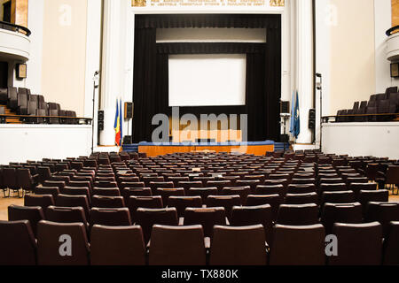 Leeren Konferenzsaal für den Gipfel mit der Europäischen Union und der NATO flags vorbereitet. Geräumige Auditorium mit Stuhlreihen, Treppen und Balkone - B Stockfoto