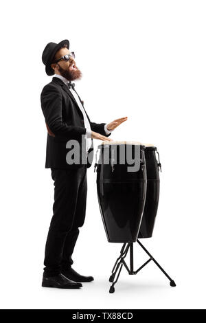 Volle Länge geschossen von einem Mann in einem schwarzen Anzug spielen conga Drums auf weißem Hintergrund Stockfoto