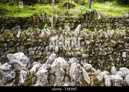 Drei sich überlappende Stein grunge Wände mit Flechten und grüne Vegetation im Park. Overlay Steinmauern Textur Hintergrund. Stockfoto