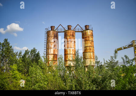 Gefallenen rusty Industrie Konzept Foto in den verlassenen Zementwerk mit alten grunge Beton und Metall strucures. Stockfoto