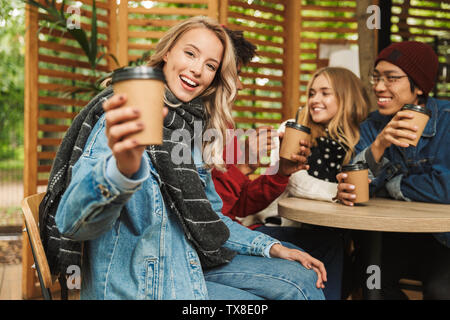 Gruppe, wenn Fröhliche multiethnischen Freunde Jugendliche lustige Zeit zusammen verbringen im Freien, Kaffee trinken in einem Café Stockfoto