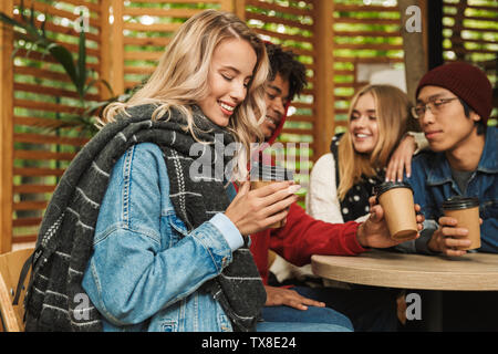 Gruppe, wenn Fröhliche multiethnischen Freunde Jugendliche lustige Zeit zusammen verbringen im Freien, Kaffee trinken in einem Café Stockfoto