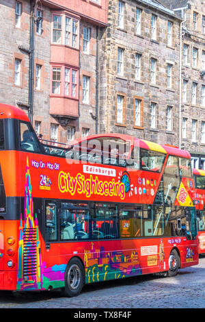 Top City Sightseeing Bus der sich seinen Weg entlang der Royal Mile offen, mit Mehrstöckigen Architektur im April Sonnenschein. Edinburgh, Schottland, Großbritannien. Stockfoto
