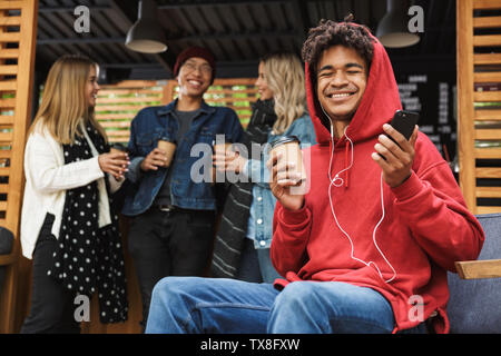 Happy multhietnic Freunde Studenten heraus zusammen hängen draußen, Musik hören mit Kopfhörern Stockfoto