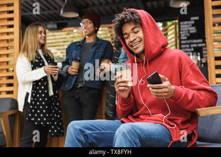 Happy multhietnic Freunde Studenten heraus zusammen hängen draußen, Musik hören mit Kopfhörern Stockfoto