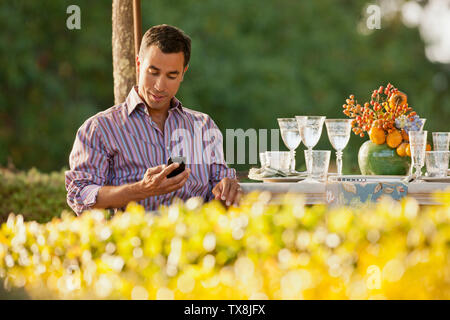 Mitte der erwachsene Mann SMS auf ein Handy. Stockfoto