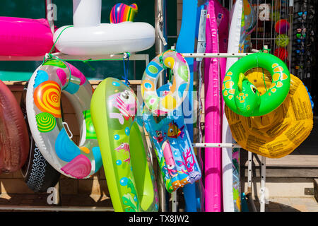 Bunte aufblasbare Strandspielzeug hängenden außerhalb eines Shop auf Finikoudis, Larnaca. Stockfoto