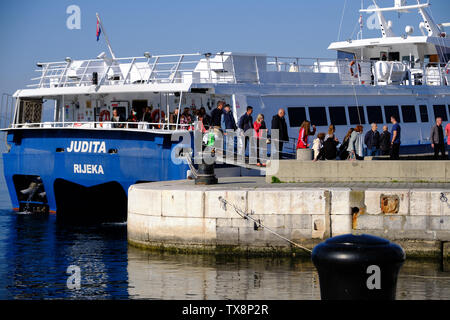 Die Passagiere aussteigen die Judita Fähre die Ankunft im Hafen. Steigen Sie auf kleinen Metall Gangway auf Beton Pier. Rijeka, Kroatien Stockfoto