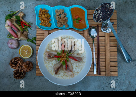 Fisch, gekochtem Reis. Congee oder conjee ist eine Art Reisbrei oder mehlsuppe beliebt in vielen asiatischen Ländern, vor allem in Ostasien, Ansicht von oben Stockfoto