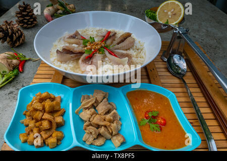 Fisch, gekochtem Reis. Congee oder conjee ist eine Art Reisbrei oder mehlsuppe beliebt in vielen asiatischen Ländern, vor allem in Ostasien, Schrägansicht vom zu Stockfoto