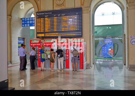 Kunden, die Fahrkarten von der automatisierten Maschine unter die Abfahrt des Zuges. Triest, Italien, 17. Juni 2019 Stockfoto