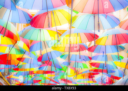 Bunte sonnenschirme Hintergrund. Bunte sonnenschirme Schweben über der Straße. Straße Dekoration. Stockfoto