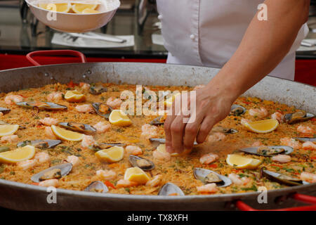 Chefkoch, der spanische Paella im Außenbereich kocht Stockfoto