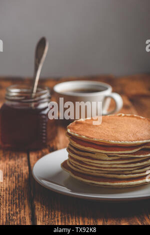 Stapel Pfannkuchen am weißen Platte über Holz- Oberfläche Stockfoto