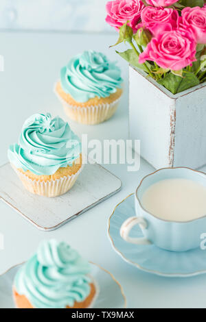 Blau vertikales Banner mit verzierten Cupcakes, Tasse Kaffee mit Milch und Blumenstrauß aus Rosen in retro shabby chic Vase - Schöne congratula Stockfoto