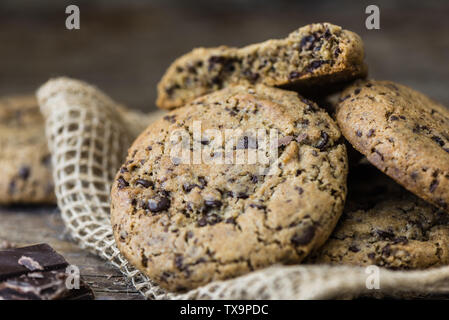 Ein Haufen Chocolate Cookies auf rustikalen Holztisch. Kekse und ähnliches Kleingebäck, gesüßt. Sie hausgemachte Kuchen. Stockfoto