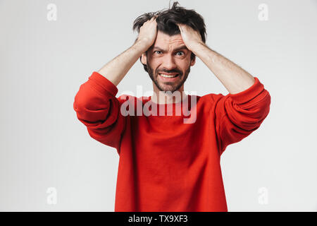 Hübscher junger Bartgeier brünett Mann, der Pullover, die auf weißem Hintergrund, Kopfschmerzen Stockfoto