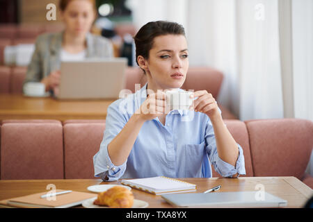 Zielstrebige Geschäftsfrau in Pause im Cafe Stockfoto