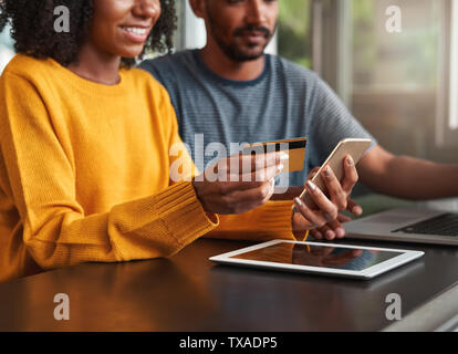 Junge Frau Einkaufen online im Café Stockfoto