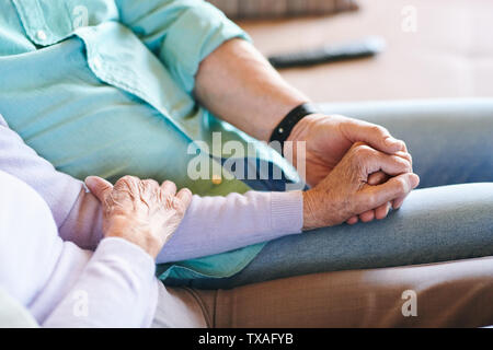 Senior der Mann und die Frau in der casualwear Holding durch die Hände Stockfoto
