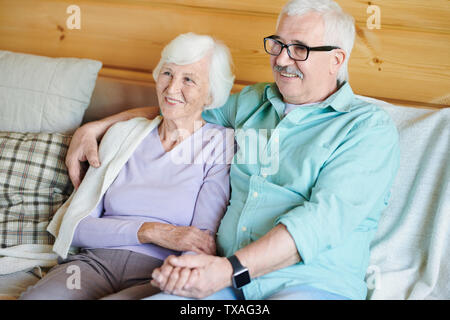 Happy Rentnerehepaar in casualwear Sitzen auf der Couch Stockfoto