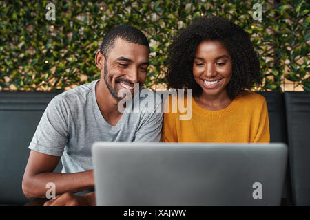 Lächelnde junge Paar mit laptop Stockfoto