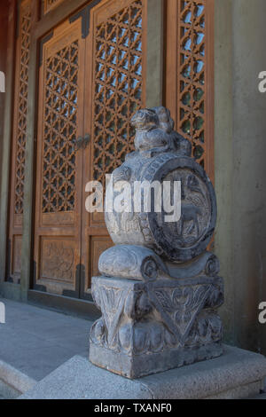 Lion Stein Damm Trommel an der hölzernen Tor Stockfoto
