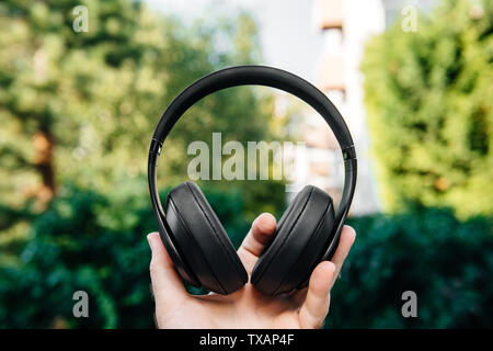 Mann Hand professioneller DJ-Kopfhörer Einheit gegen Green Park Hintergrund Stockfoto