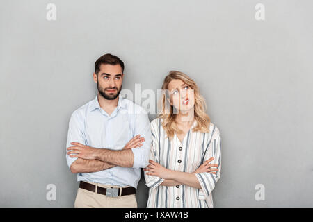 Foto schönes Paar legere Kleidung denken, während nach oben betrachten Copyspace über grauer Hintergrund Stockfoto