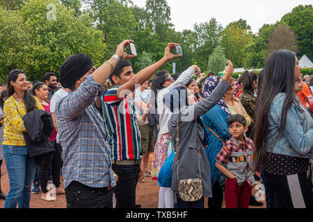 Eine multikulturelle, vor allem Scots-Punjabi, Menschenmenge genießen ein Akt bei Glasgow Mela2019, einem kostenlosen multikulturellen Festival im Kelvingrove Park, im West End. Stockfoto
