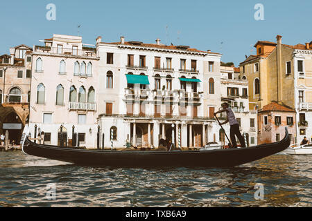 Venedig, Italien - Juli 2, 2018: Closeup Fotografie der Gondel mit Menschen und Gondoliere, im Hintergrund der historischen Gebäude des Grand Canal (Kann Stockfoto