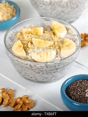 Chia Pudding aus Milch, Bananen und dekoriert, Nussbaum Stockfoto