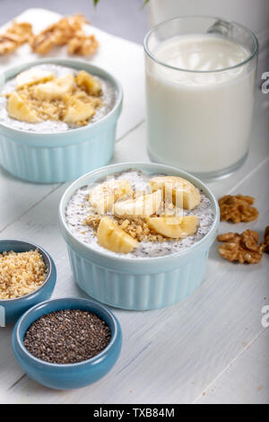 Chia Pudding aus Milch, Bananen und dekoriert, Nussbaum Stockfoto