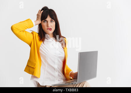 Bild eines schönen jungen verwechselt Business woman über Weiß mit Laptop Computer Hintergrund posiert. Stockfoto