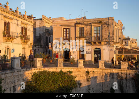 Syrakus, Italien - 12. März 2018: Die schönen Straßen von Ortigia, in Syrakus, mit goldenen Abendlicht an ihren Gebäuden und Menschen Stockfoto