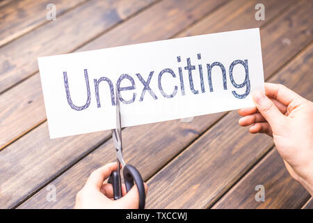 Frau schneidet Weißbuch mit Word unexciting auf Tisch Stockfoto